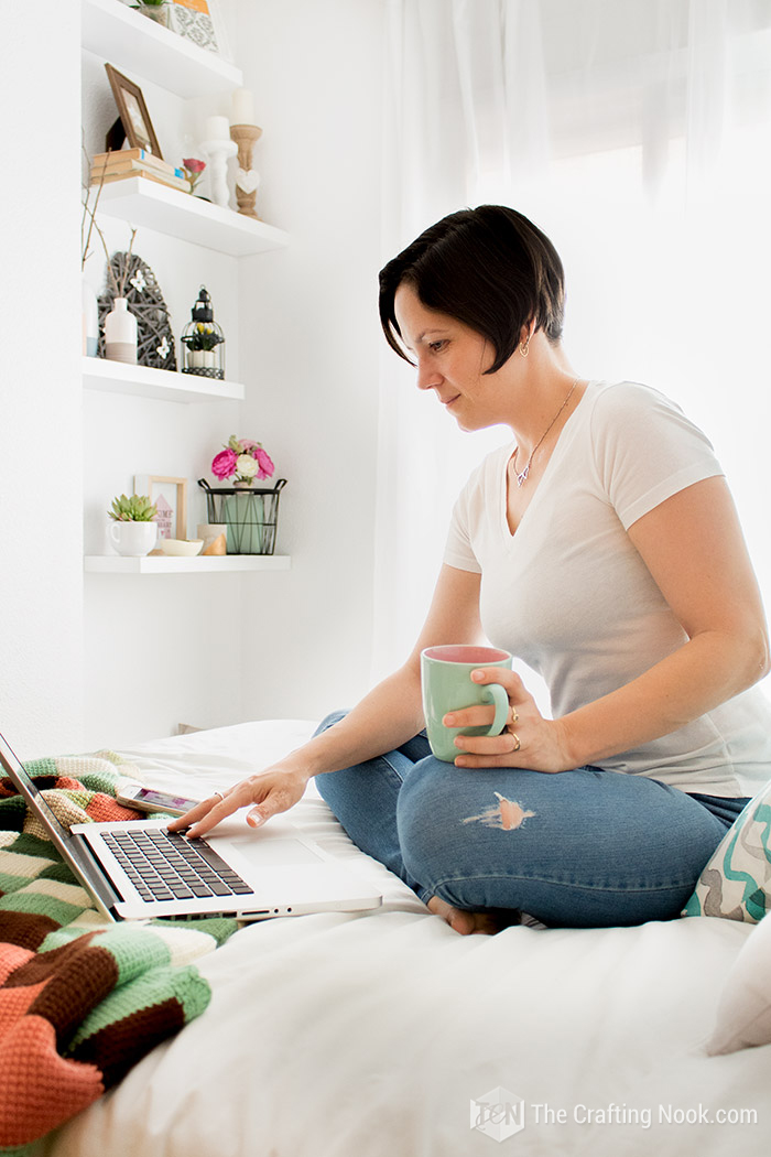 A photo of me on the bed looking at the laptop with a cup of coffee in hand